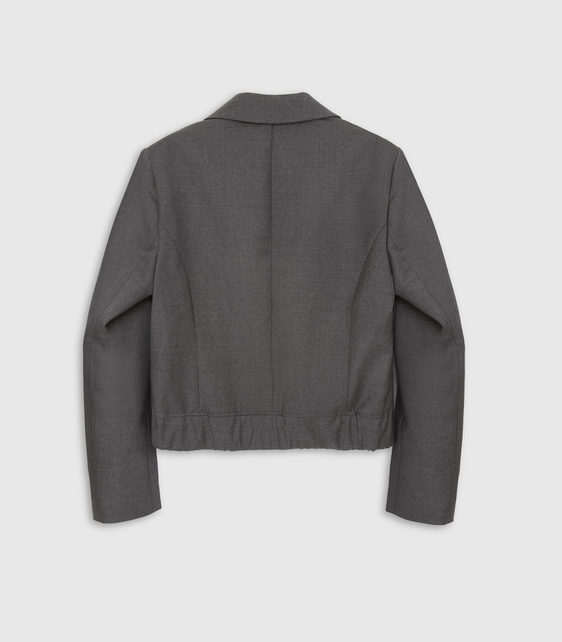 A dark gray cropped jacket shown from the back, featuring a pointed collar, long sleeves, and a gathered waist seam, photographed against a light gray background.