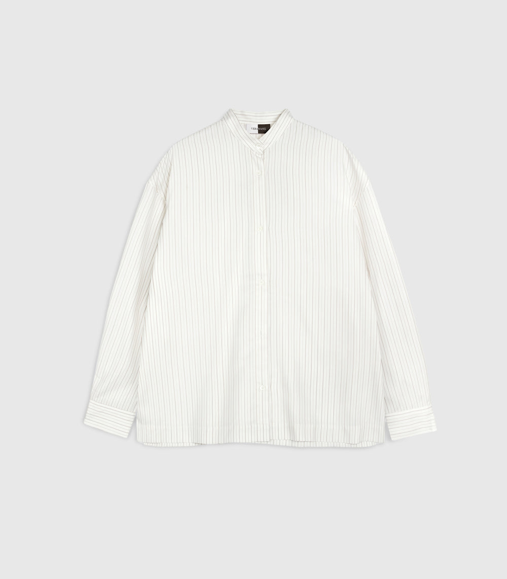 Flat lay product view of a relaxed-fit ivory boyfriend shirt featuring fine vertical pinstripes. The design showcases a structured band collar with a small top button, a full-length tonal button placket, dropped shoulder seams, and long sleeves with wide, buttoned cuffs, presented against a clean light grey backdrop.