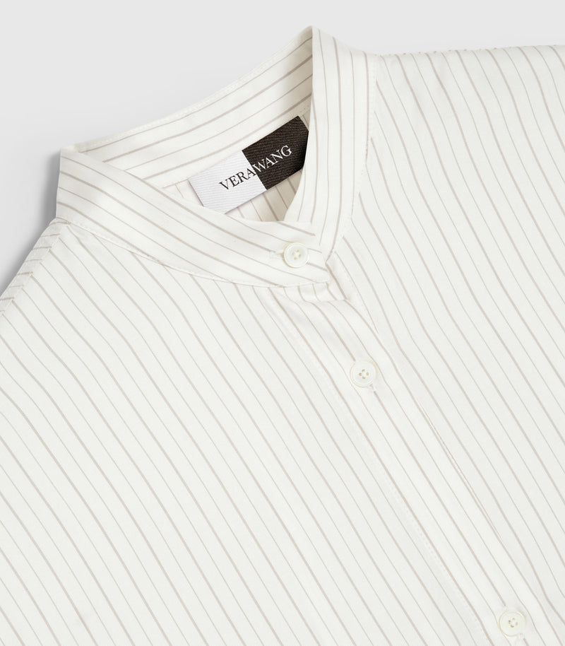 An angled, close-up product view of a shirt neckline, showcasing a structured band collar stitched with horizontal pinstripes that contrast against the vertical pinstripes of the main body. The design highlights a neat front button placket with tonal four-hole buttons and a prominent split black-and-white inner neck 'VERA WANG' brand label against a light grey background.