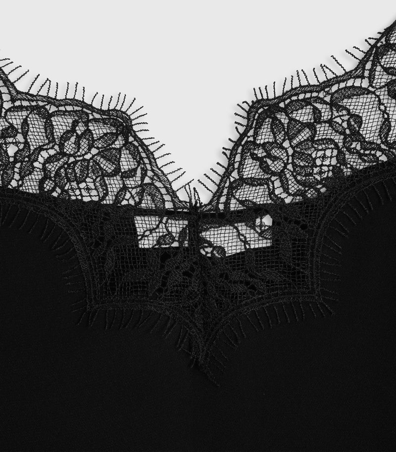 Close-up of a black lace bra or lingerie top with a wide floral lace neckline and scalloped edges against a light gray background.