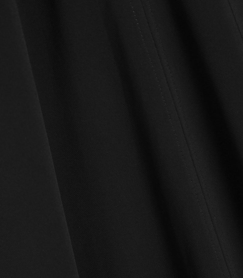 Close-up of black fabric with soft folds and a subtle stitched seam running vertically.