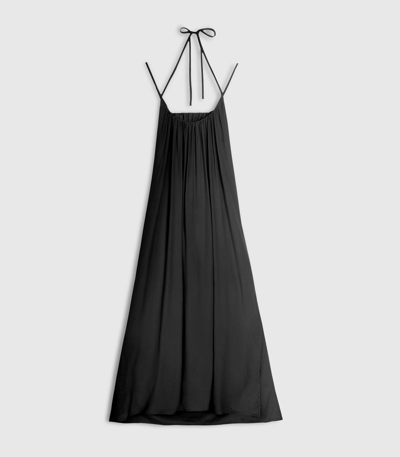 Flat lay product view of a fluid maxi-length black slip dress, showcasing a gathered scoop neckline, thin shoulder straps that transition into an adjustable halter tie, and a relaxed, flowing A-line silhouette against a light grey background.