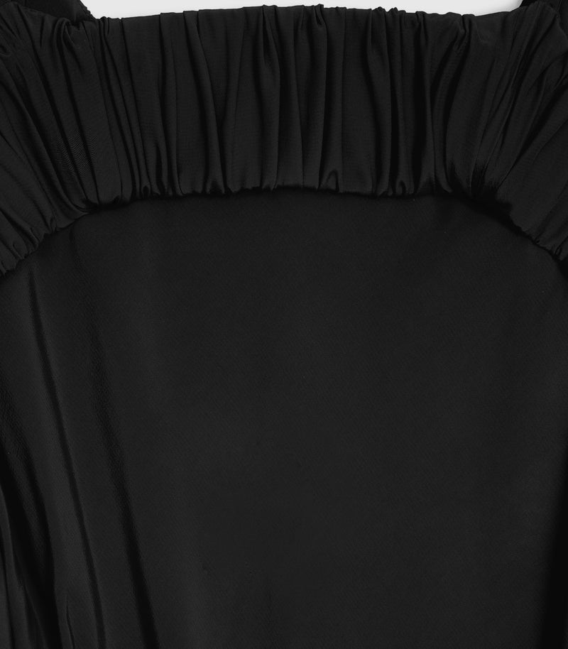 Close-up product view of the upper back on a black slip dress, showcasing a thick horizontal band with tight, uniform ruched gathering framing a clean scoop-shaped open-back cut-out, set against smooth matte fabric.