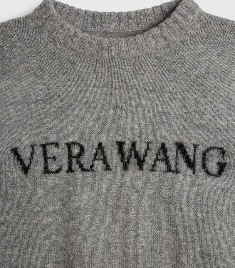 Close-up of a gray knit sweater with the brand name 'VERAWANG' knitted across the chest in black.