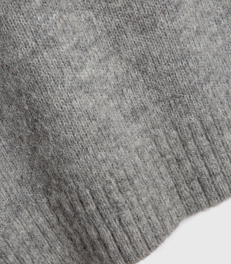 Close-up of a gray knit fabric with a ribbed cuff, showing the texture and weave against a white background.