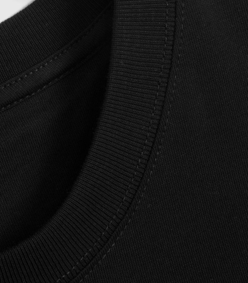A detailed shot of the hem of a black t-shirt.