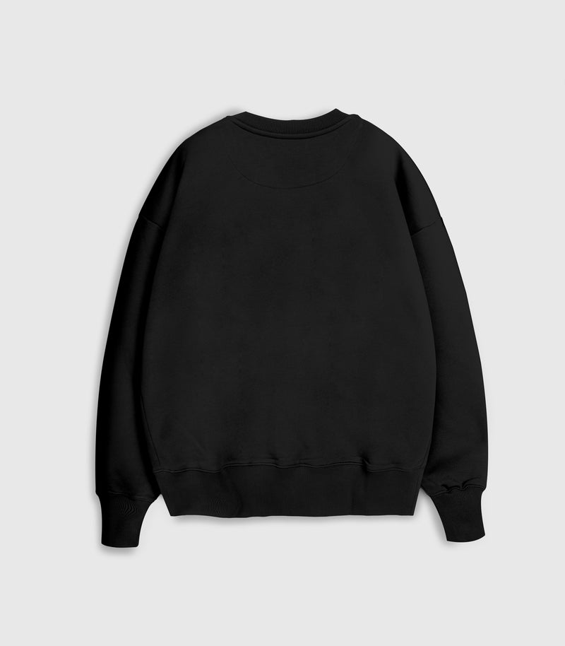Flat lay product view of a relaxed-fit black crewneck sweatshirt, complete with a ribbed collar, hem, and cuffs against a light grey background.