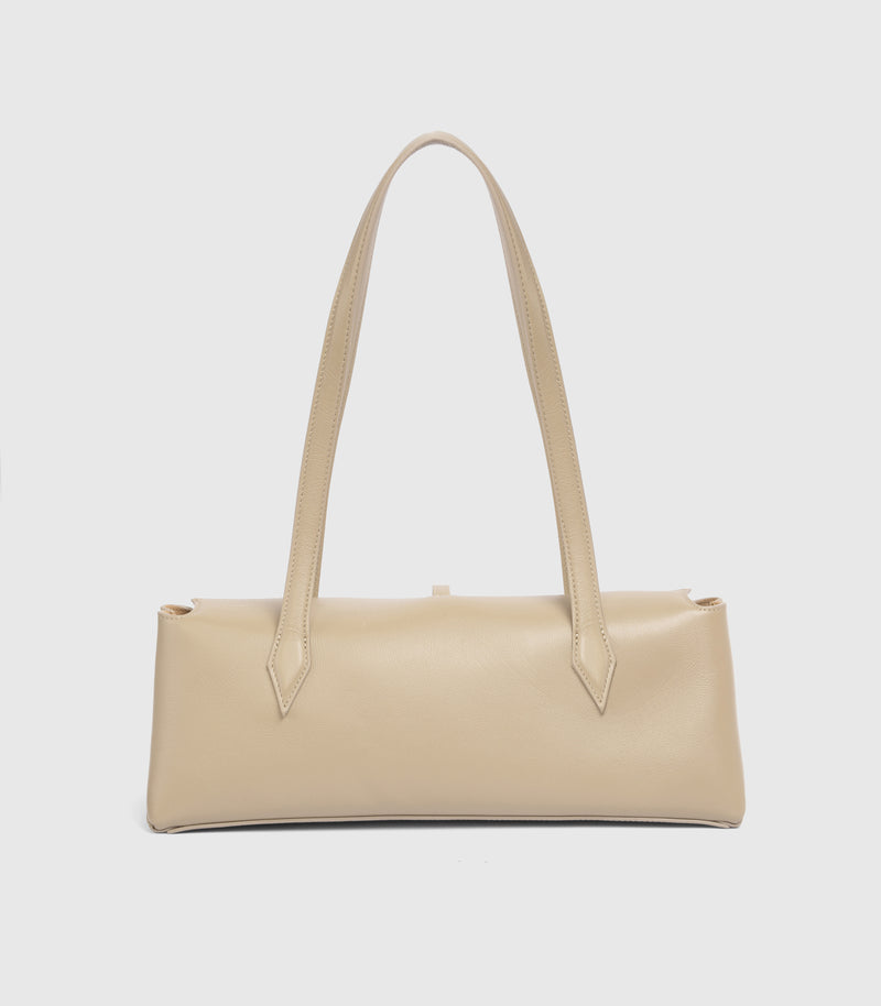 A light beige leather shoulder bag with a structured rectangular body and long double shoulder straps, shown against a plain light gray background.