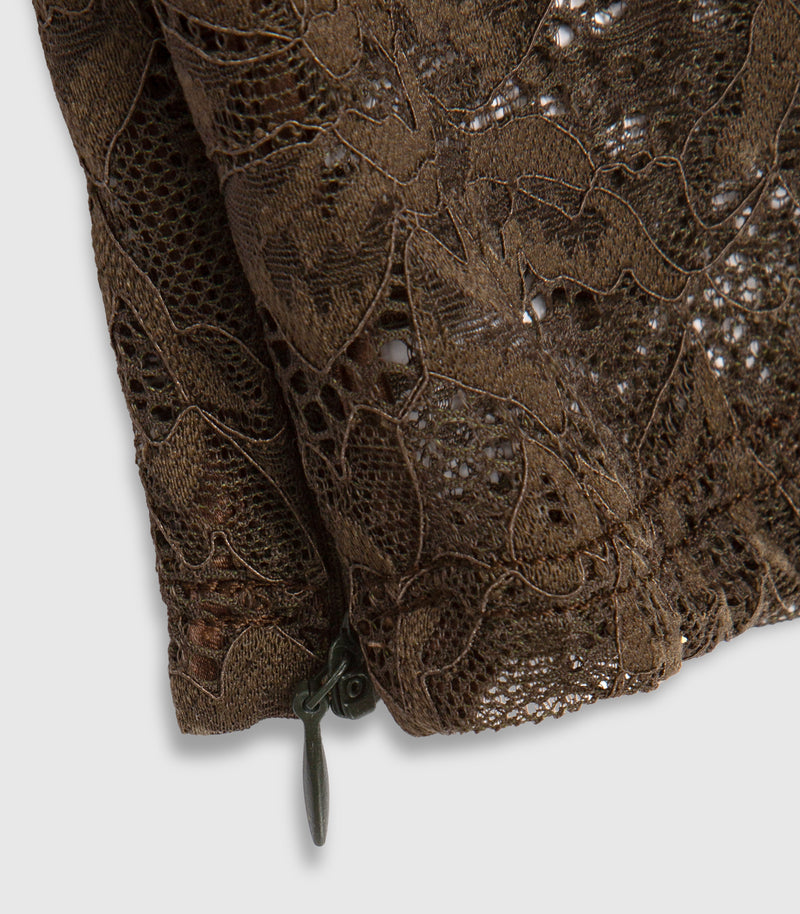 Close up of dark brown lace leggings showing the garments details and zip fastening at the ankle.