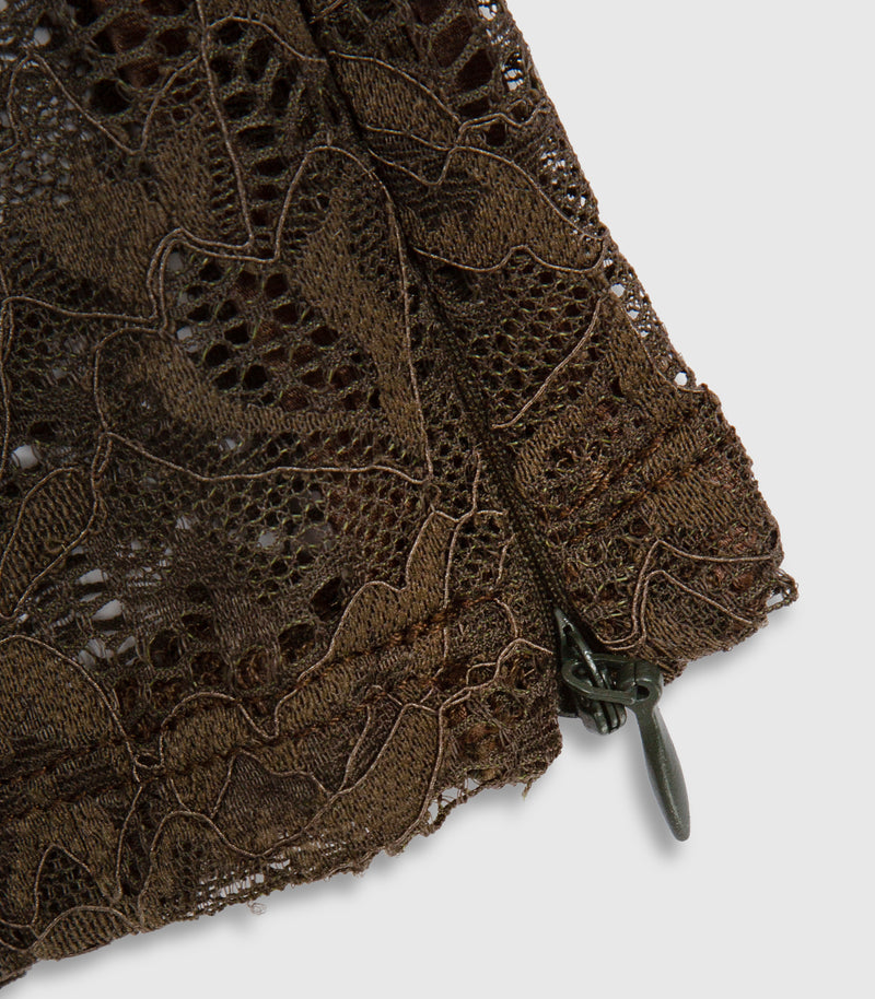 Close up of dark brown lace leggings showing the garments details and zip fastening at the ankle.