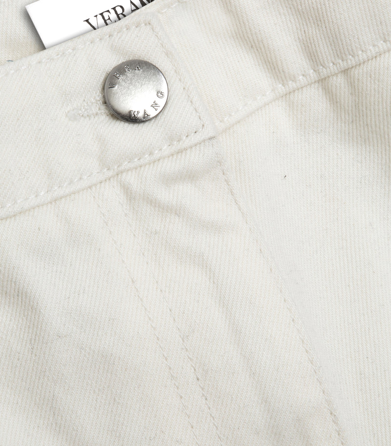 Close-up product view of the crotch and  silver button-up closure on the ecru wide-leg balloon jeans, showcasing the 'VERA WANG' detailing on the silver button and tonal stitching, against a white background.