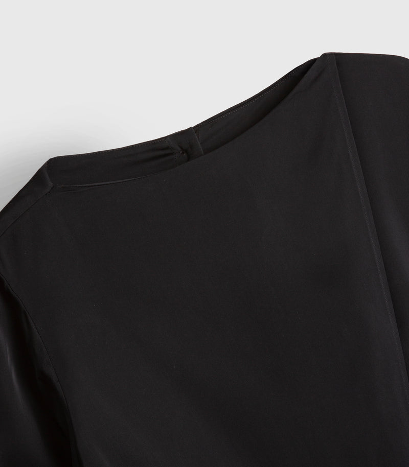 Close-up of a black long-sleeve top showing the back neckline and shoulder seam against a light gray background.