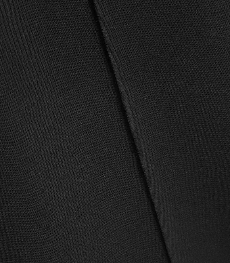A close-up of a solid black textured fabric with a diagonal fold line.
