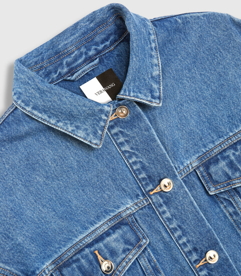 Close-up of a blue denim jacket with a pointed collar, silver-toned snap buttons, and a visible 