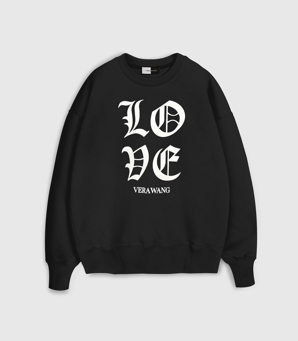 A black crewneck sweatshirt with 'LOVE VERA WANG' spell-out logo across the front, against a white background.