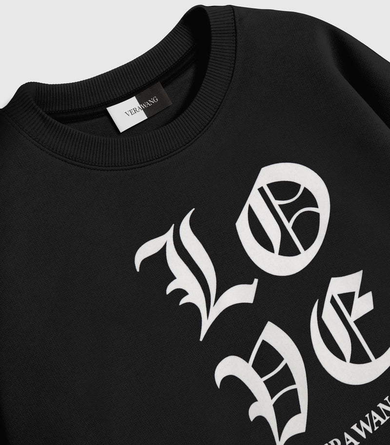 A black crewneck sweatshirt with 'LOVE VERA WANG' spell-out logo across the chest, against a white background.