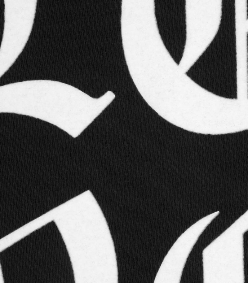 A hyper close-up product shot focusing on the chest graphic of a black cotton t-shirt, showcasing the crisp white printed 'LOVE' text.