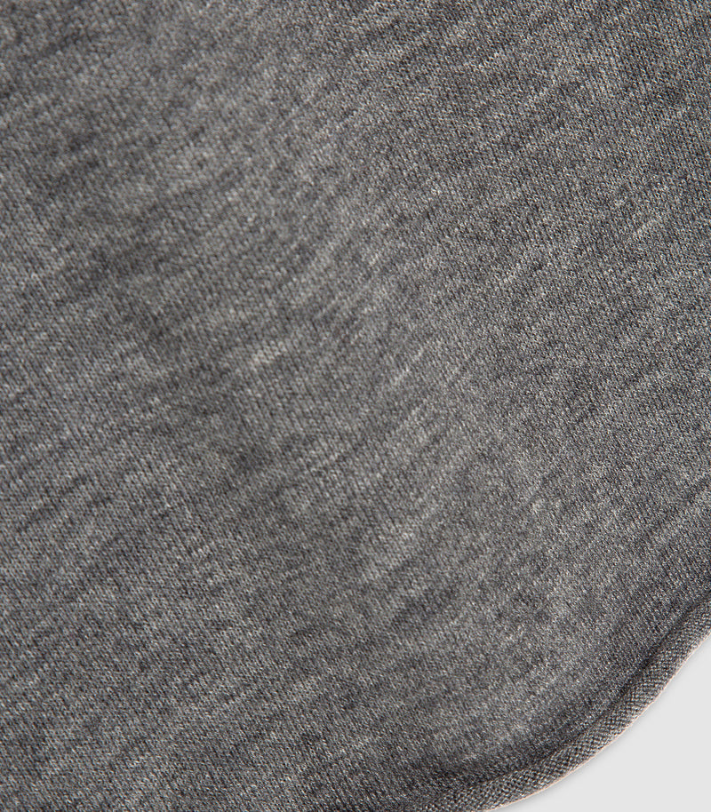 Close-up of a dark heather gray knit fabric texture with a curved hem detail on the right side.