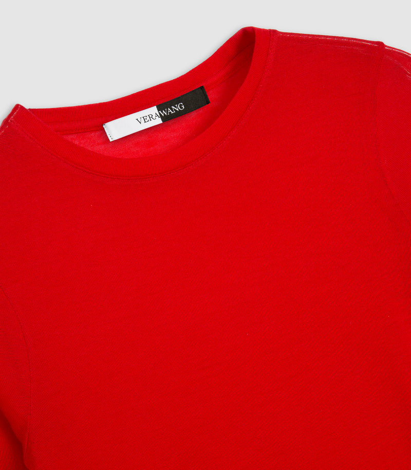 A close-up of a bright red crewneck sweatshirt showing the inner collar with a black and white brand label that reads 'VERY WANG'.