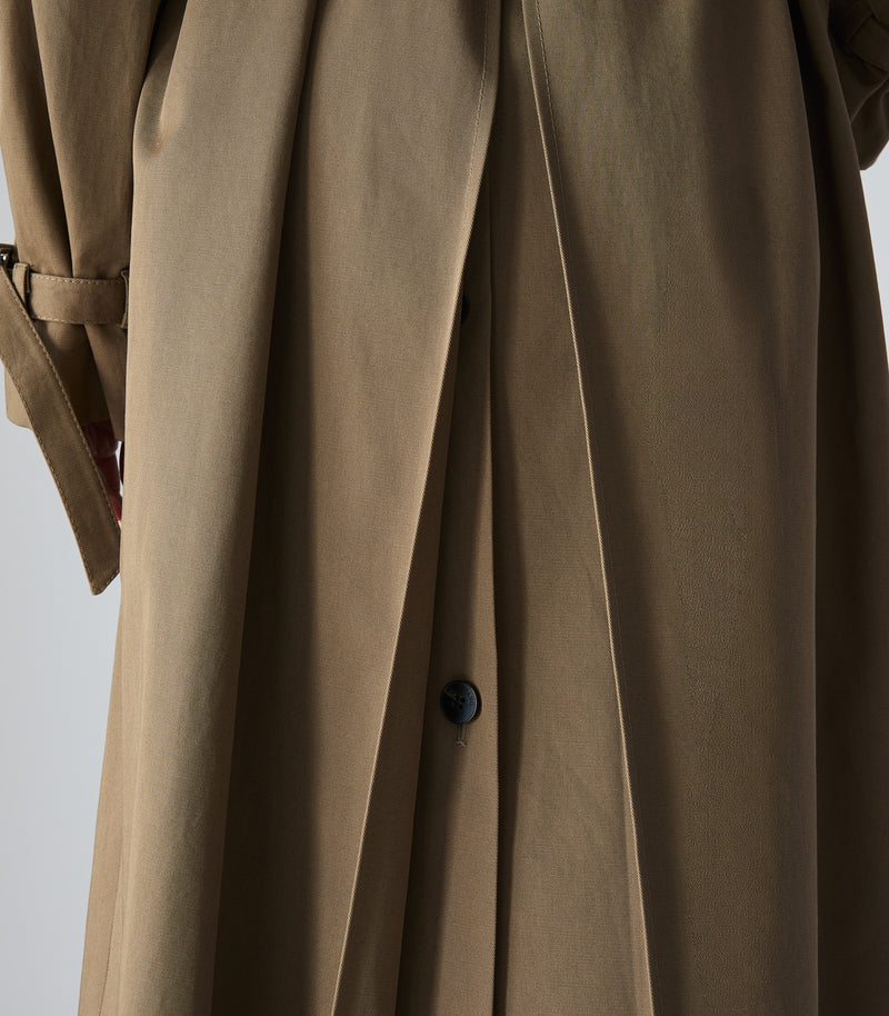 Close-up of a taupe-brown trench coat with a dark button and belt detail, shown against a light gray background.