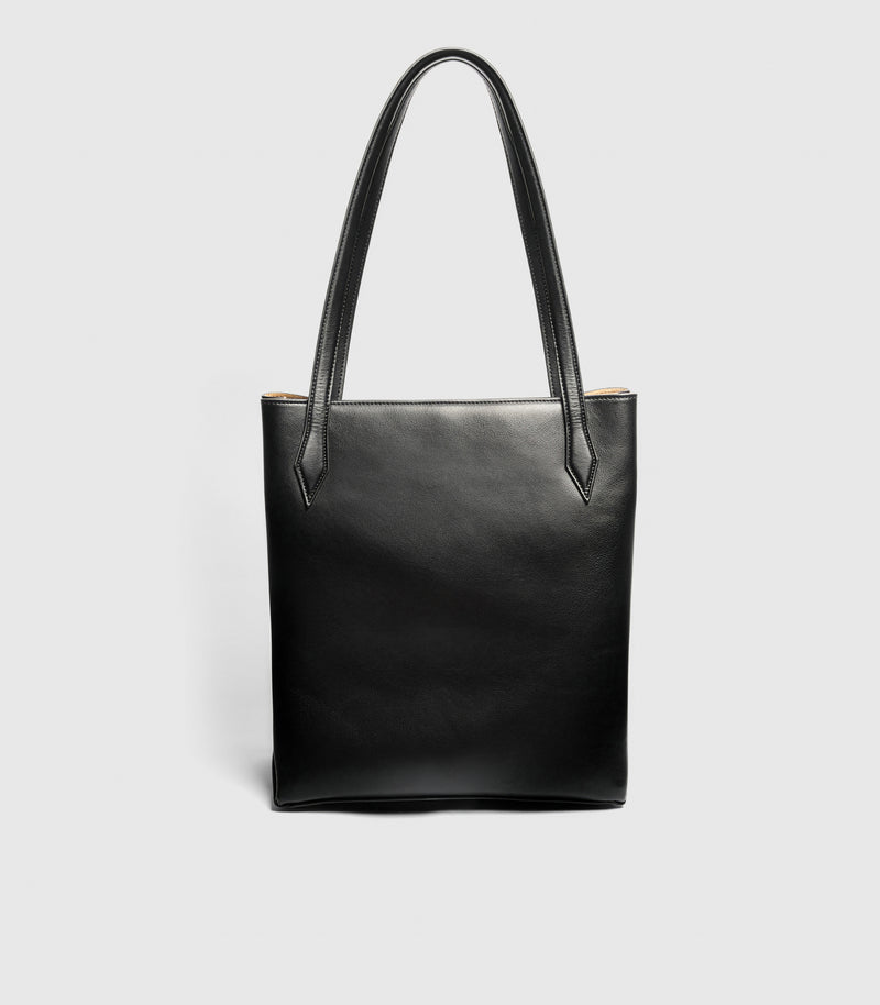 A black leather tote bag with two shoulder straps, shown against a light gray background.
