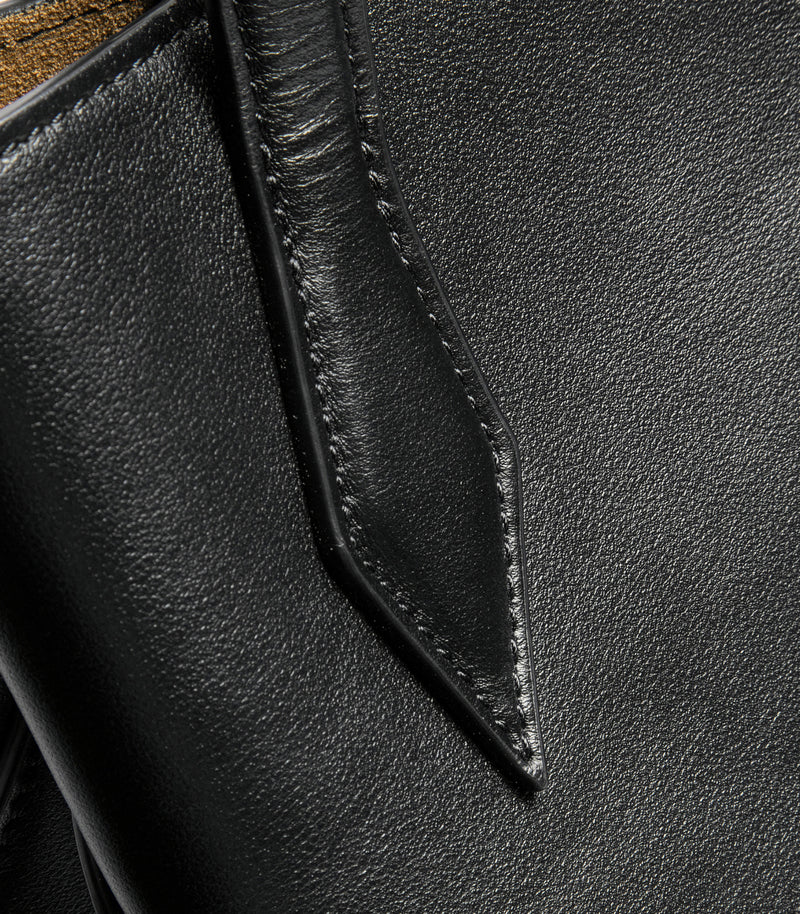 Close-up of a black leather bag with stitching detail