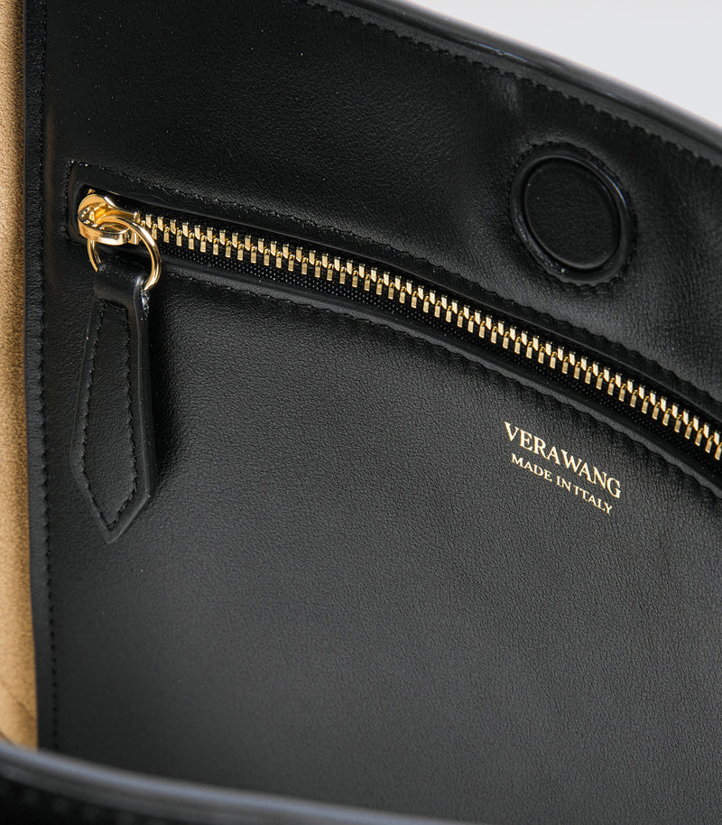 Close-up of a black handbag with gold zipper and 'VERAWANG' branding.