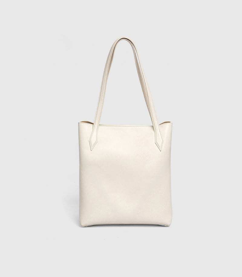 An off-white leather tote bag with two shoulder straps, shown against a light gray background.