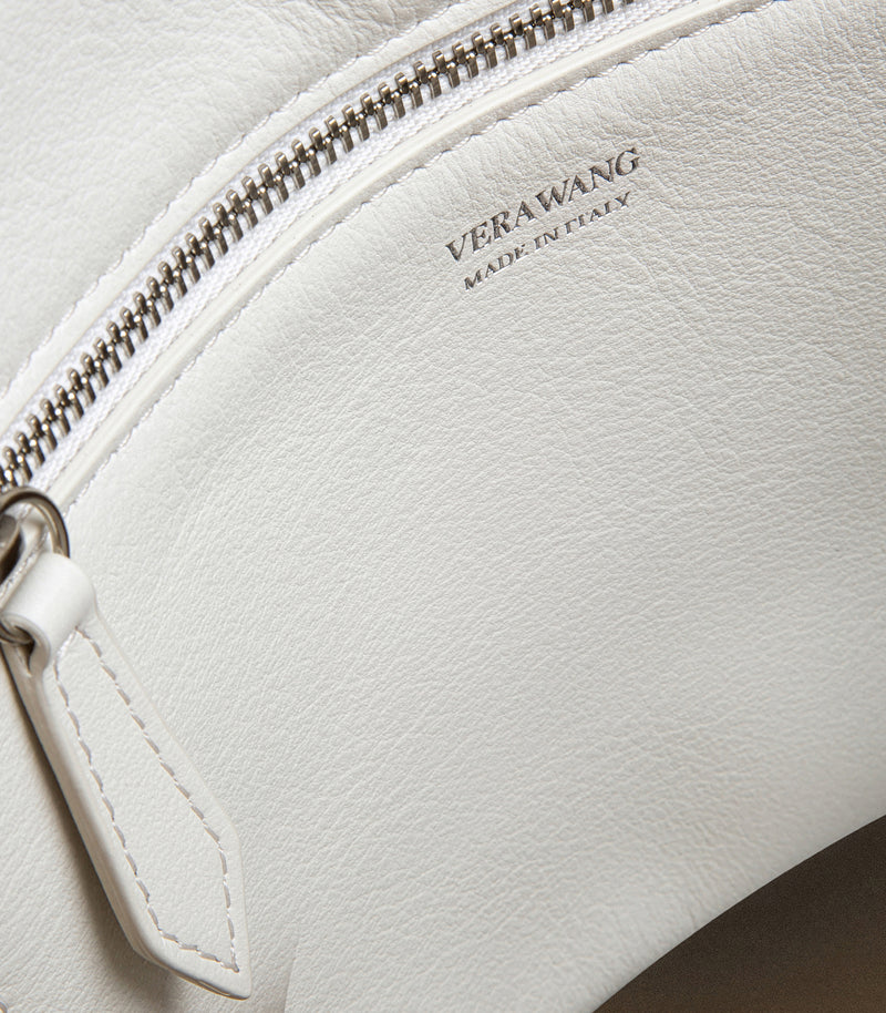 Close-up of a white leather zippered pouch with silver zipper and the debossed brand name 'VERAWANG MADE IN ITALY' on the front.