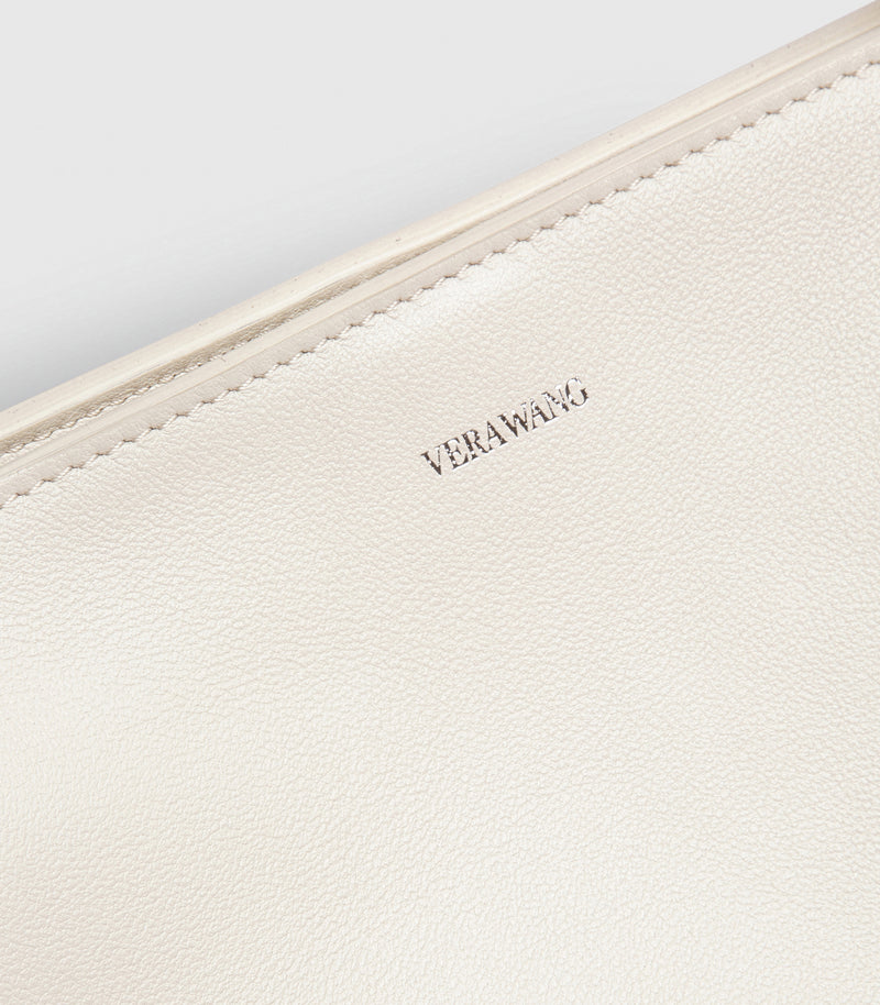 Close-up of a cream-colored pebbled leather bag with the brand name 'VERAWANG' debossed on the front, set against a matching light background.