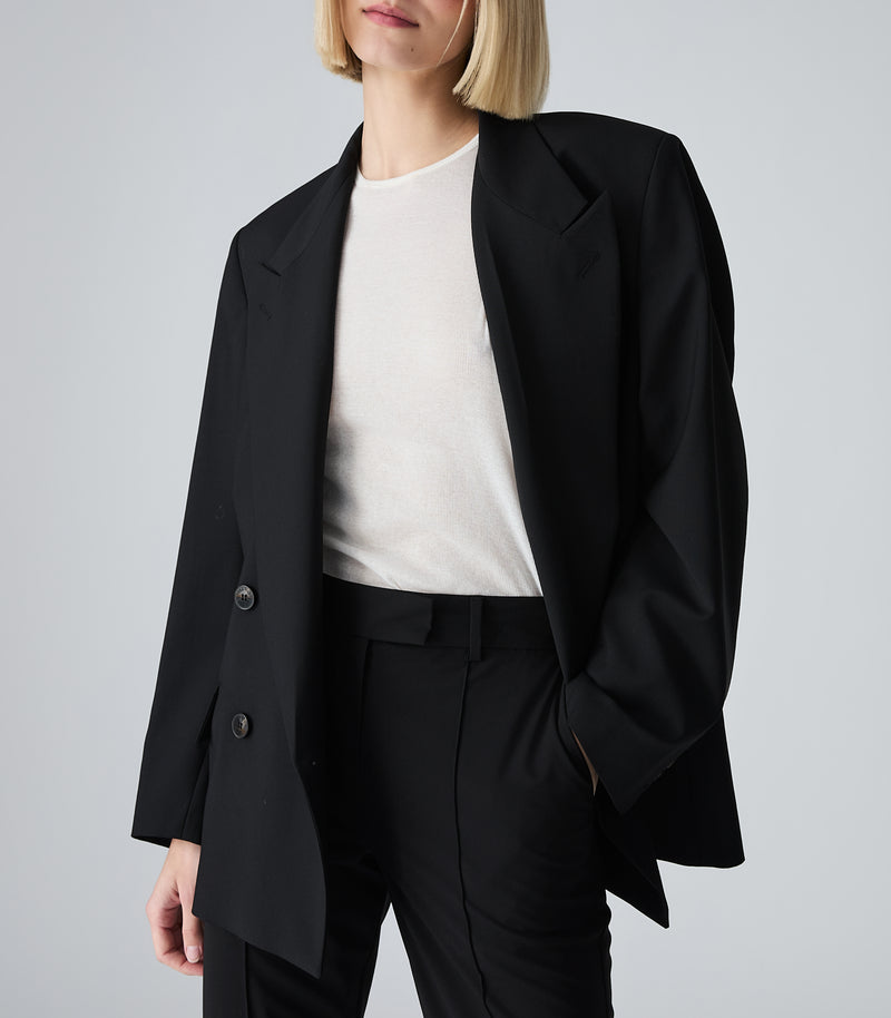 Displays a model wearing the Black 'Vera Wang' branded Miles F35 Stretch Wool Blazer