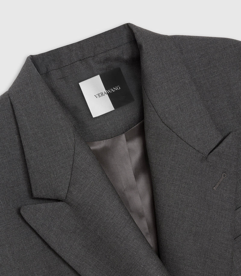 Close-up of a dark gray textured blazer jacket with a black and white brand label reading VERWANT inside the collar, showing a satin gray inner lining.