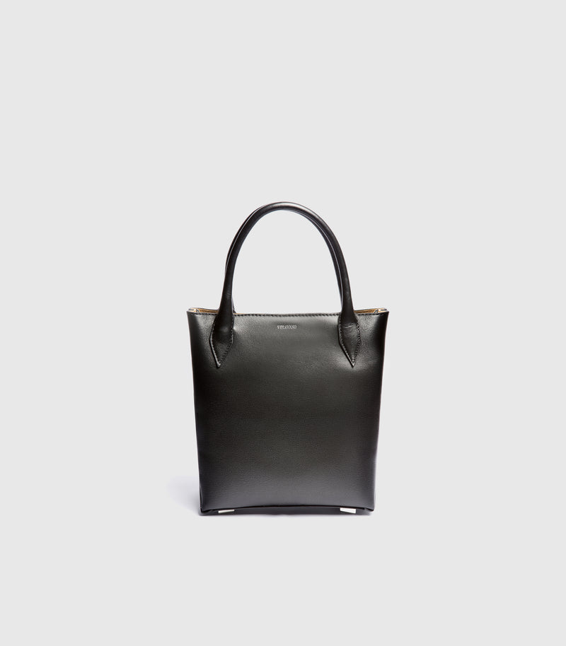 A black leather tote bag with double top handles, shown from the front against a light gray background.
