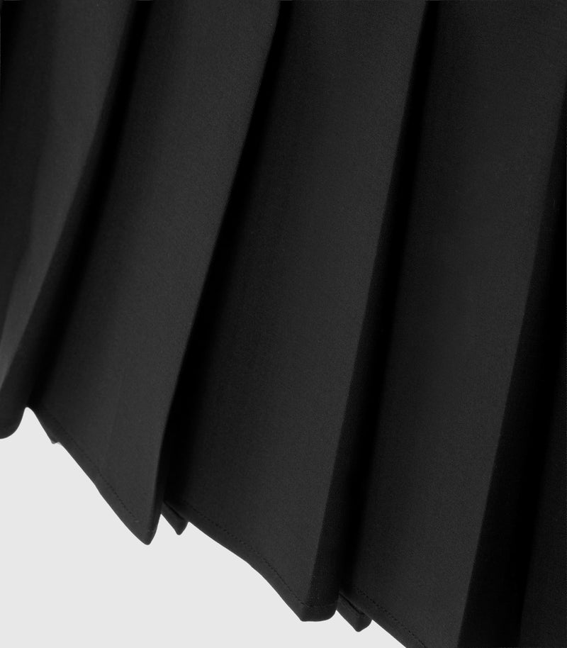 Close-up of a black pleated skirt, showing the texture and folds of the material against a light gray background.