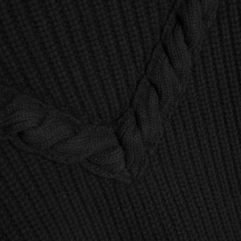 Close-up of a black ribbed knit fabric with a braided accent detail.