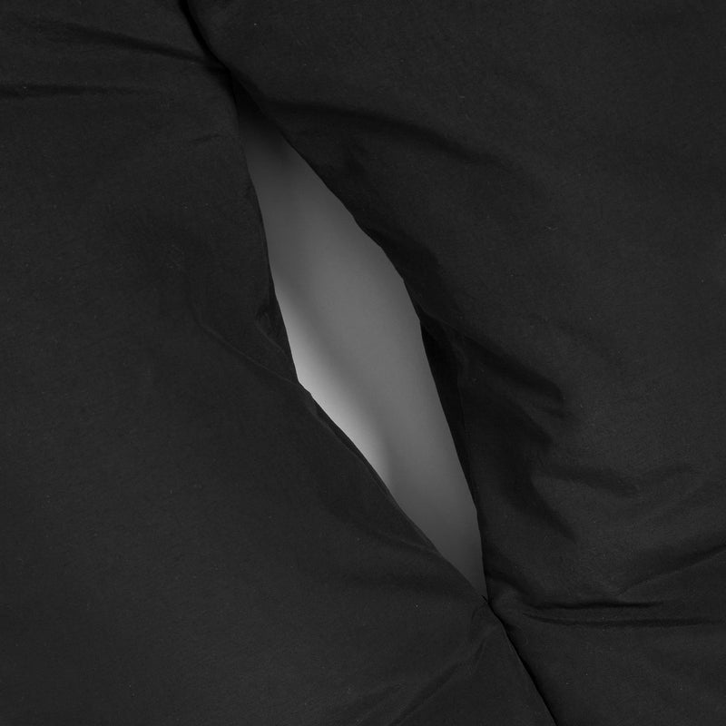 Close-up of black fabric with a central seam or opening showing a light gray interior.