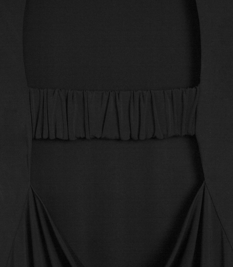A macro close-up product view focusing on the mid-back construction of a matte black dress. The shot highlights a thick, horizontal modesty strap crafted with fine, dense vertical gathers and ruching that spans across an open-back cut-out. Below the elasticated band, the smooth knit fabric anchors into soft, symmetrical cowl draping that gathers fluidly into the lower lower-back seams.