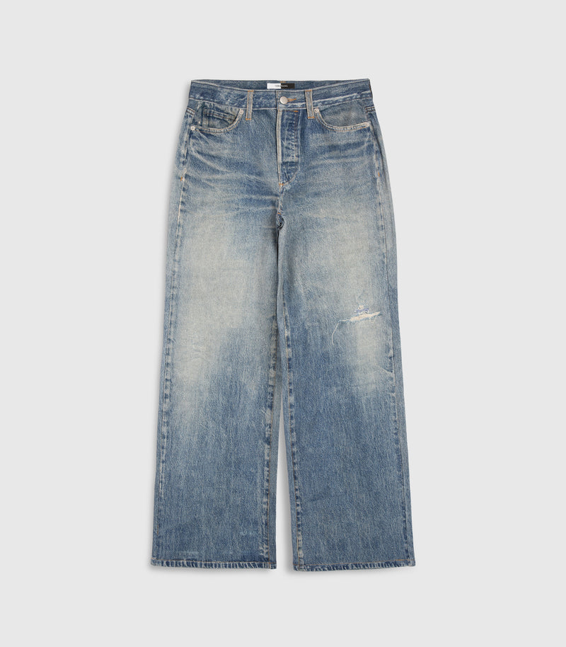 Light blue wide-leg denim-illusion  pants with a faded wash and a small distressed detail on the left thigh, shown flat against a light gray background.