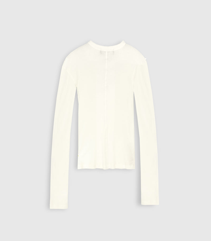 The back view of an ivory white sheer jersey long-sleeve top from Vera Wang, highlighting a central vertical seam and extra-long sleeves. The lightweight knit piece is shot flat against a solid light gray studio background.