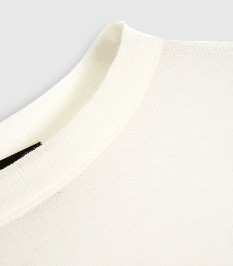A close-up detail of the high crew neckline on an ivory white sheer jersey top from Vera Wang. The shot showcases the fine, lightweight ribbed knit texture and stitched collar seam against a clean, minimal background.
