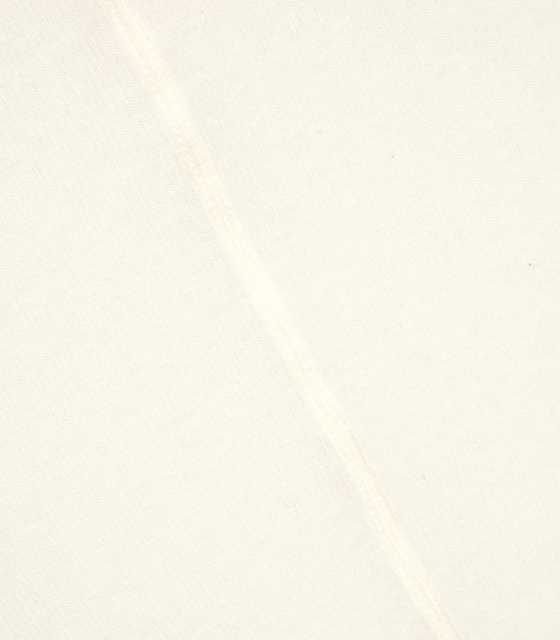 A macro close-up detail highlighting the central back seam on an ivory white sheer jersey top from Vera Wang. The shot showcases the precision stitching of the vertical seam against the fine, lightweight knit fabric texture.