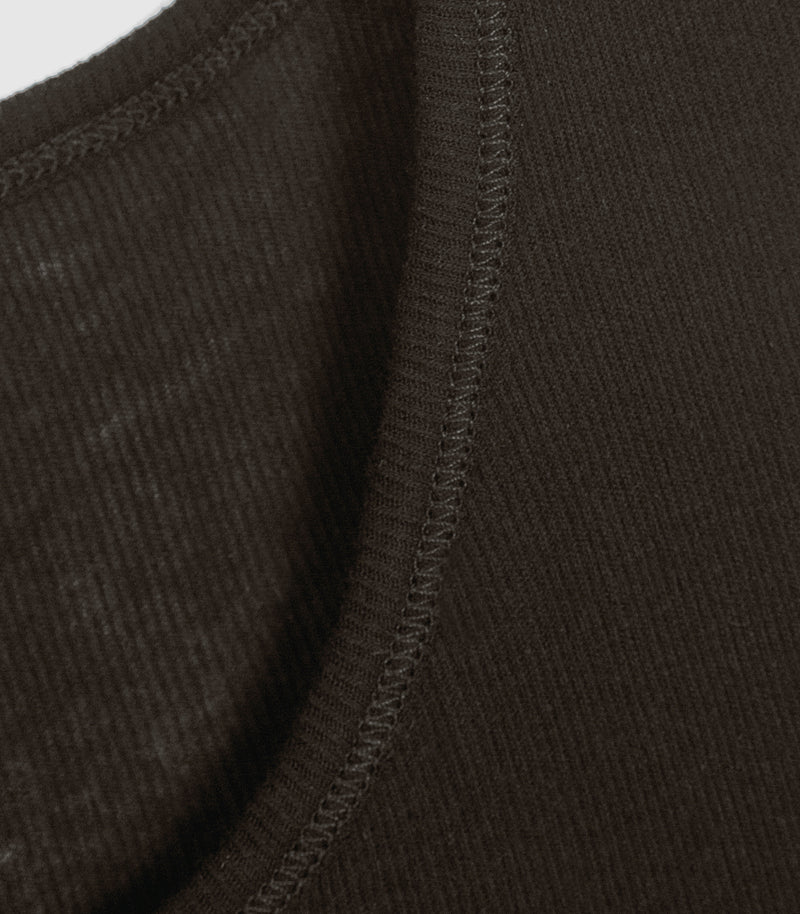 Close-up of a dark brown ribbed knit fabric with a curved neckline and double-stitched edge.