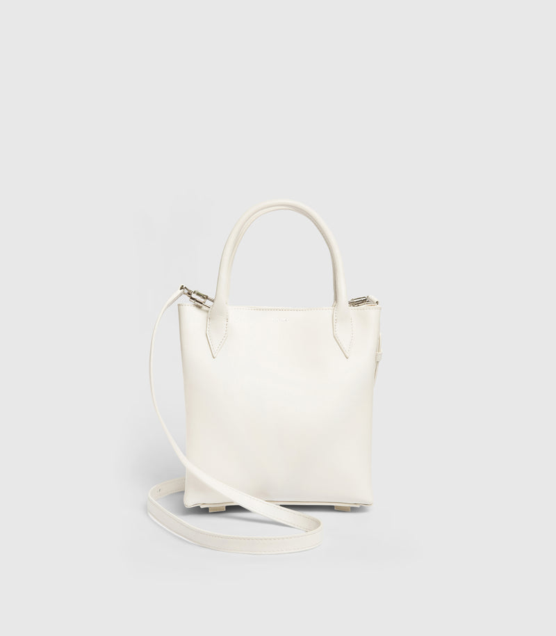 A structured white leather handbag with double top handles and a matching shoulder strap, displayed on a clean light gray background.