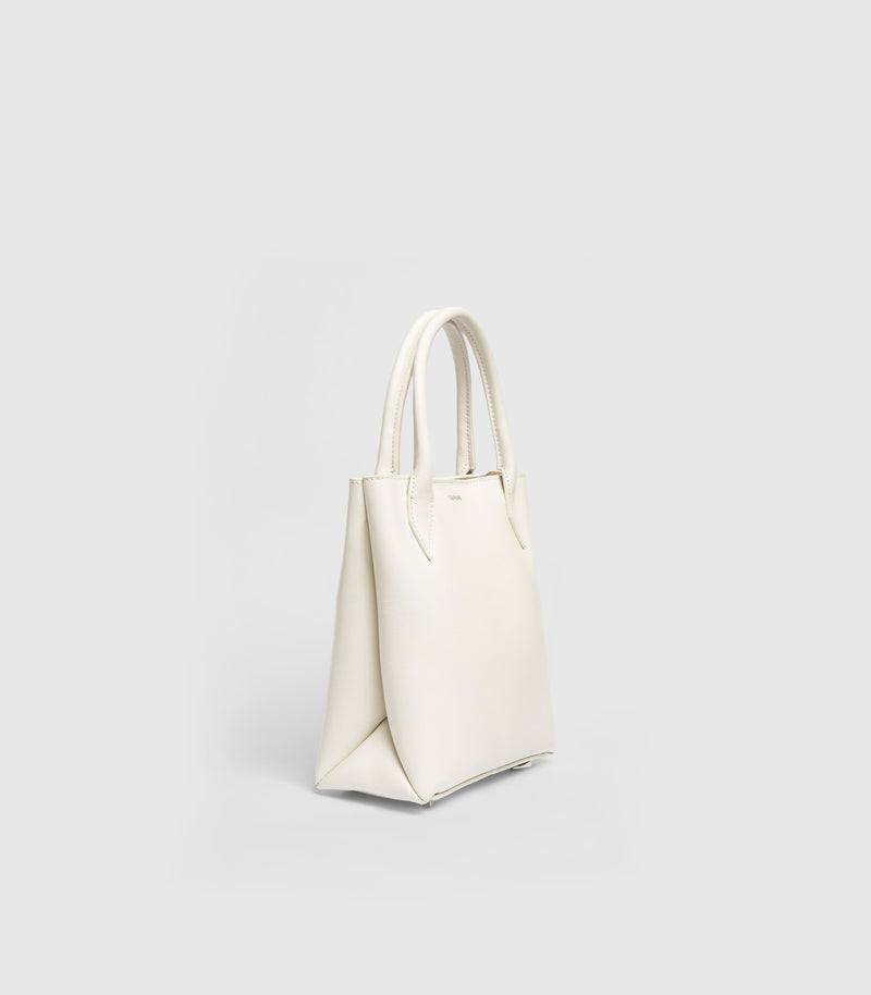 An off-white leather tote bag with double top handles, shown from a three-quarter angle on a light gray background.