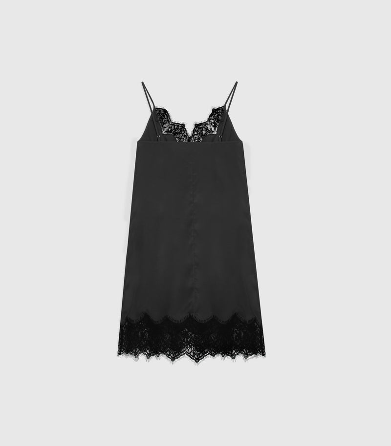 A black satin slip dress with delicate black lace trim at the scoop neckline and hem, displayed against a solid light gray background.