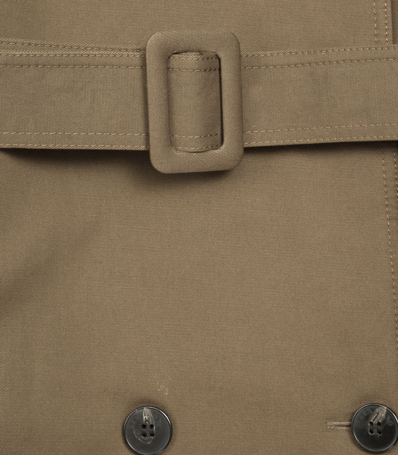 Close-up of a taupe-brown trench coat with a dark button and belt detail.