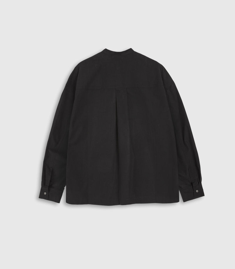A black long-sleeve button-up shirt shown from the back, featuring a subtle vertical pleat down the center back, laid flat on a light gray background.