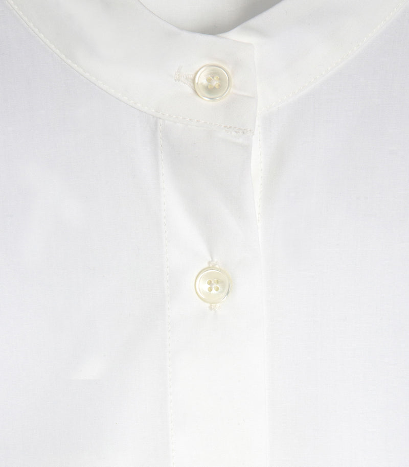 Close-up of a white collared mock neck shirt with two cream-colored buttons on the front placket.