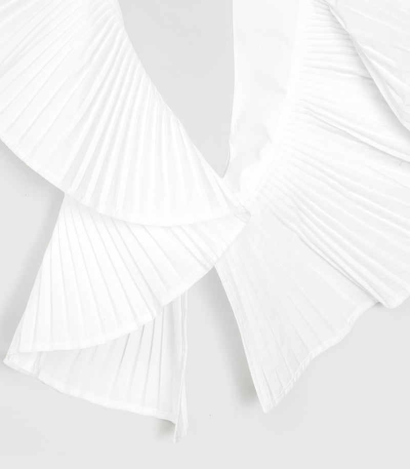 Close-up of a white pleated scarf with layered ruffle details on a light gray background.