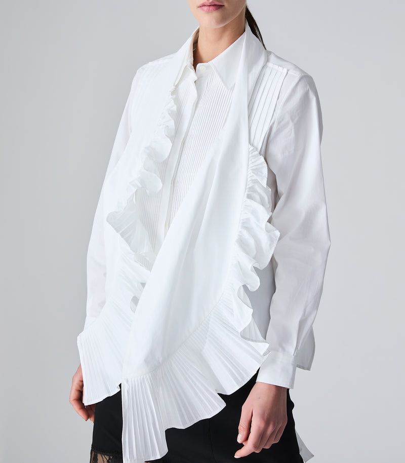 A white long-sleeve blouse with pleated details, paired with a white scarf that has dramatic ruffle and pleated details, worn by a model against a light gray studio background.